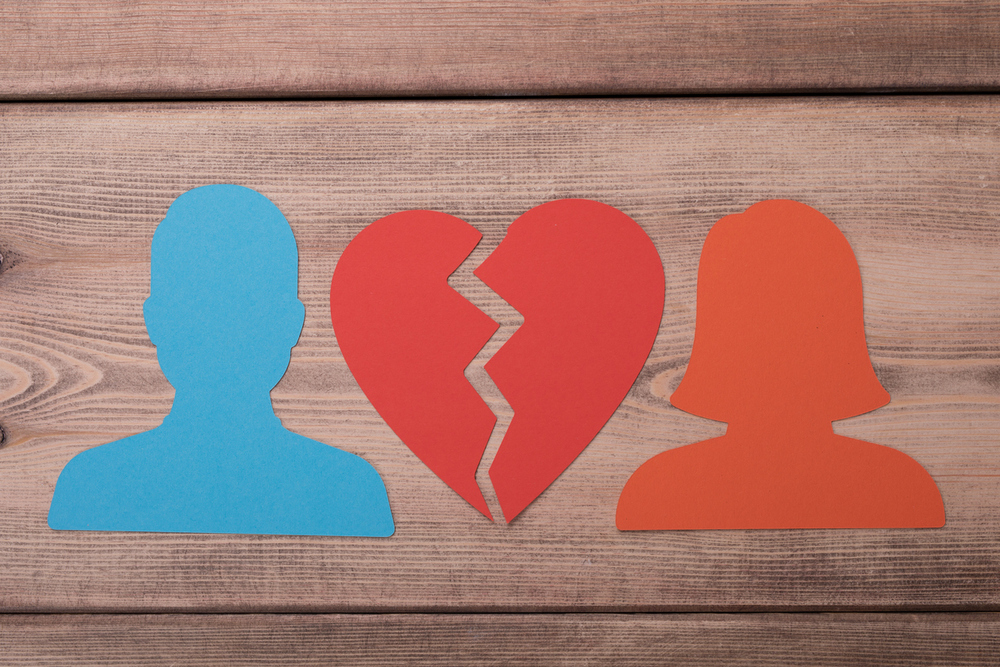 Männliche und weiblicher Kopf aus Papier und ein gebrochenes Herz. 